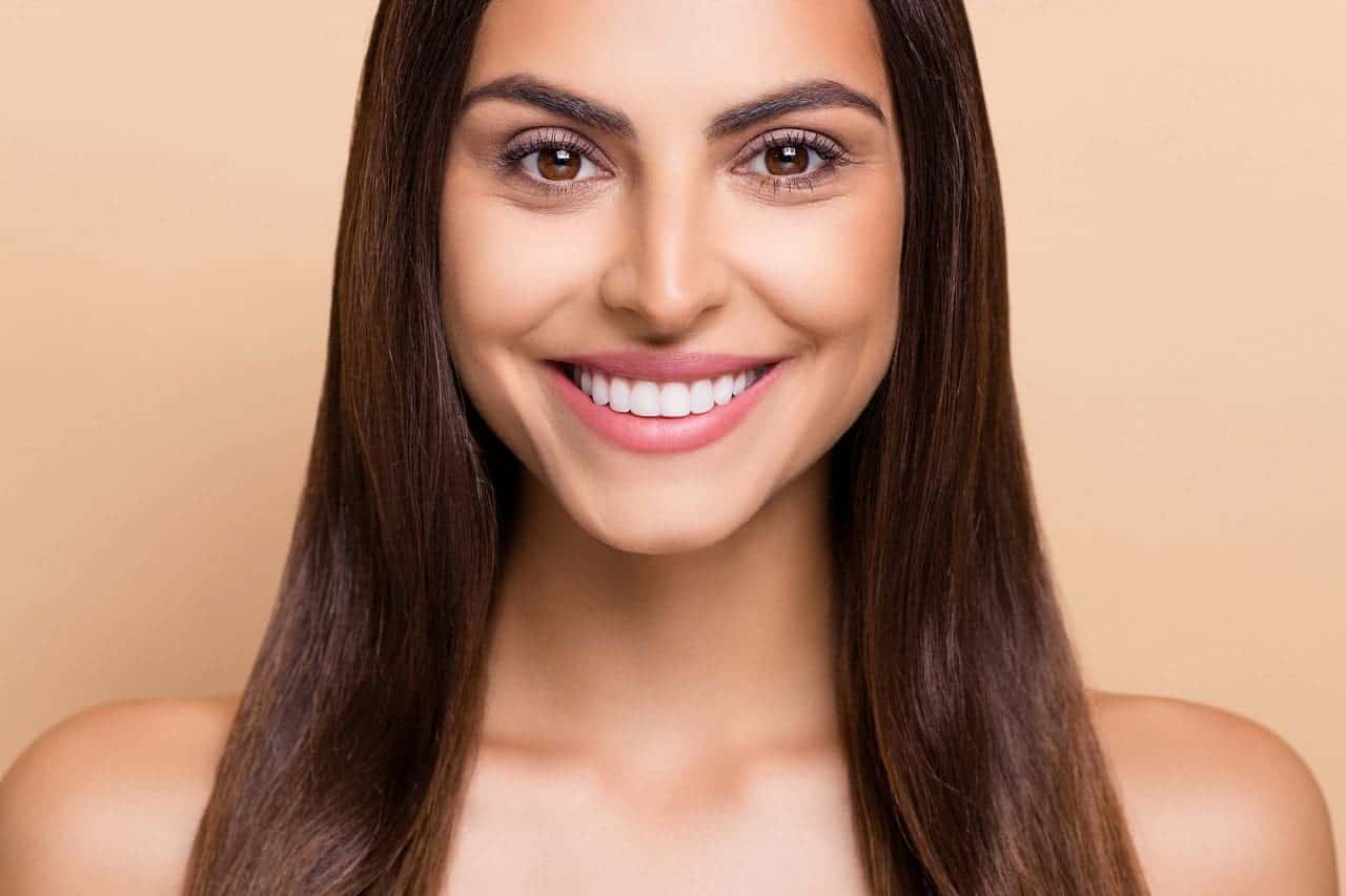 mujer sonriendo con dientes perfectos mujer sonriendo con dientes perfectos - Aniversario Clínica Dental Benalúa