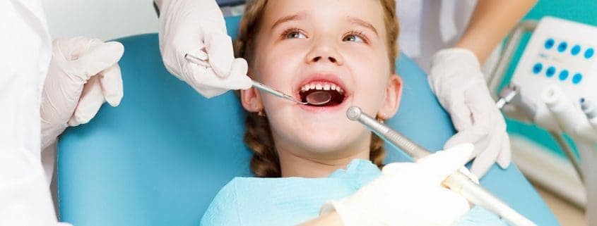 niña visitando dentista - tratamiento dental para niños