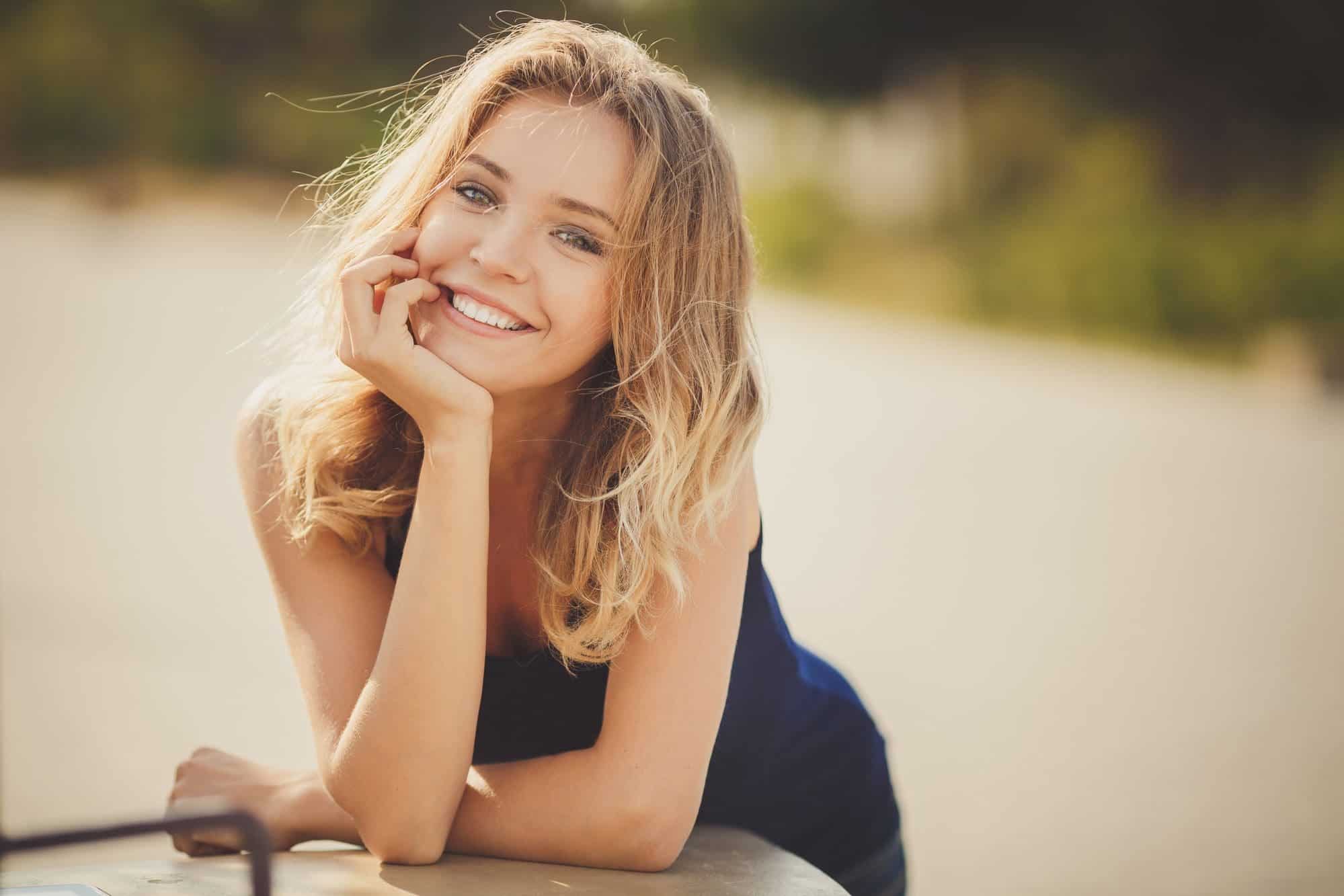 Retrato de una joven hermosa mujer rubia sonriente al aire libre - anorexia y bulimia en dientes