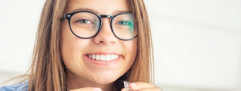 Chica joven con aparatos dentales invisibles