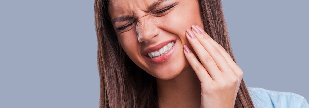 Mujer que sufre de dolor de muelas - ir al dentista durante el confinamiento