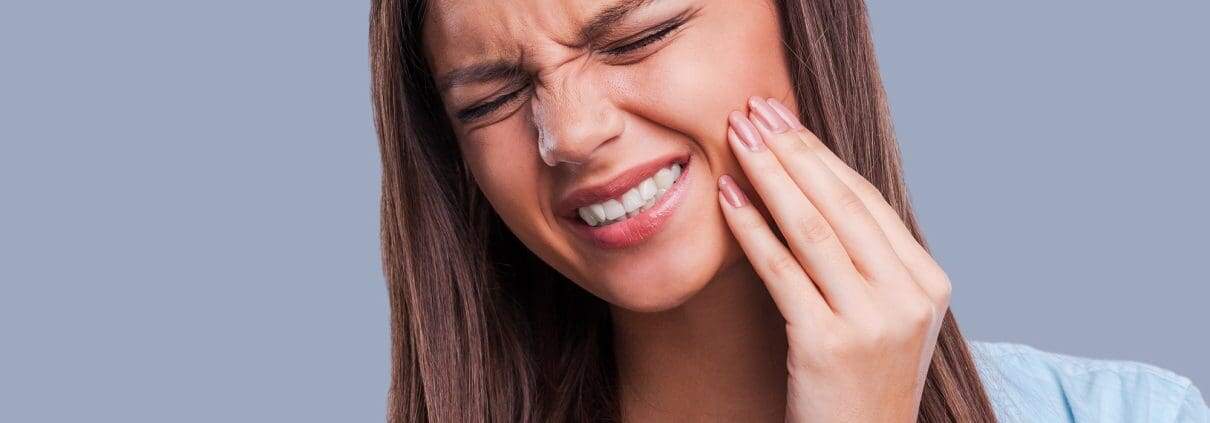 ¿Debo ir al dentista durante el confinamiento? 1 Mujer que sufre de dolor de muelas - ir al dentista durante el confinamiento