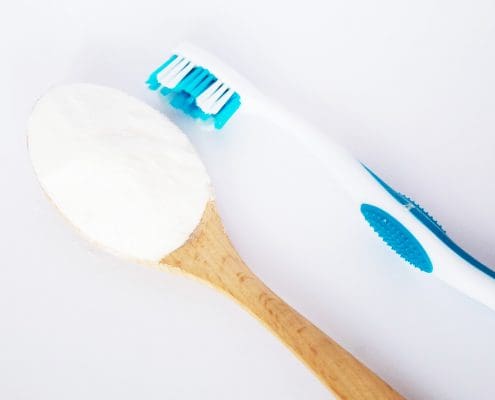 Bicarbonato de sodio en una cuchara y un cepillo de dientes