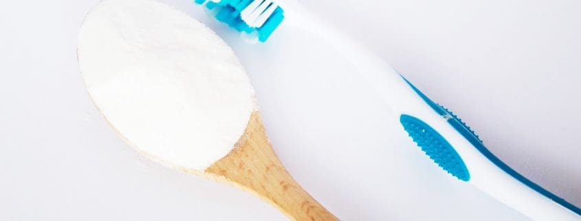 Bicarbonato de sodio en una cuchara y un cepillo de dientes