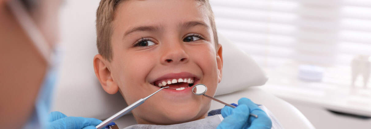 La Importancia del Sellado Dental en Niños: Prevención de Caries 1 Niño sonriendo durante una revisión dental infantil en consulta de odontopediatría en Alicante