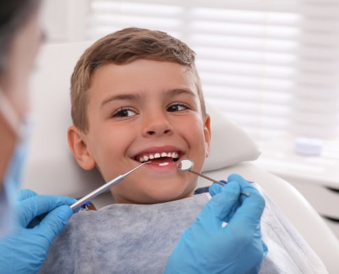 Niño sonriendo durante una revisión dental infantil en consulta de odontopediatría en Alicante