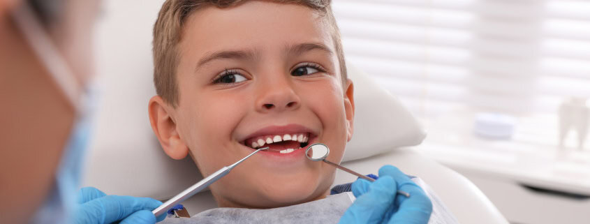 La Importancia del Sellado Dental en Niños: Prevención de Caries 16 Niño sonriendo durante una revisión dental infantil en consulta de odontopediatría en Alicante