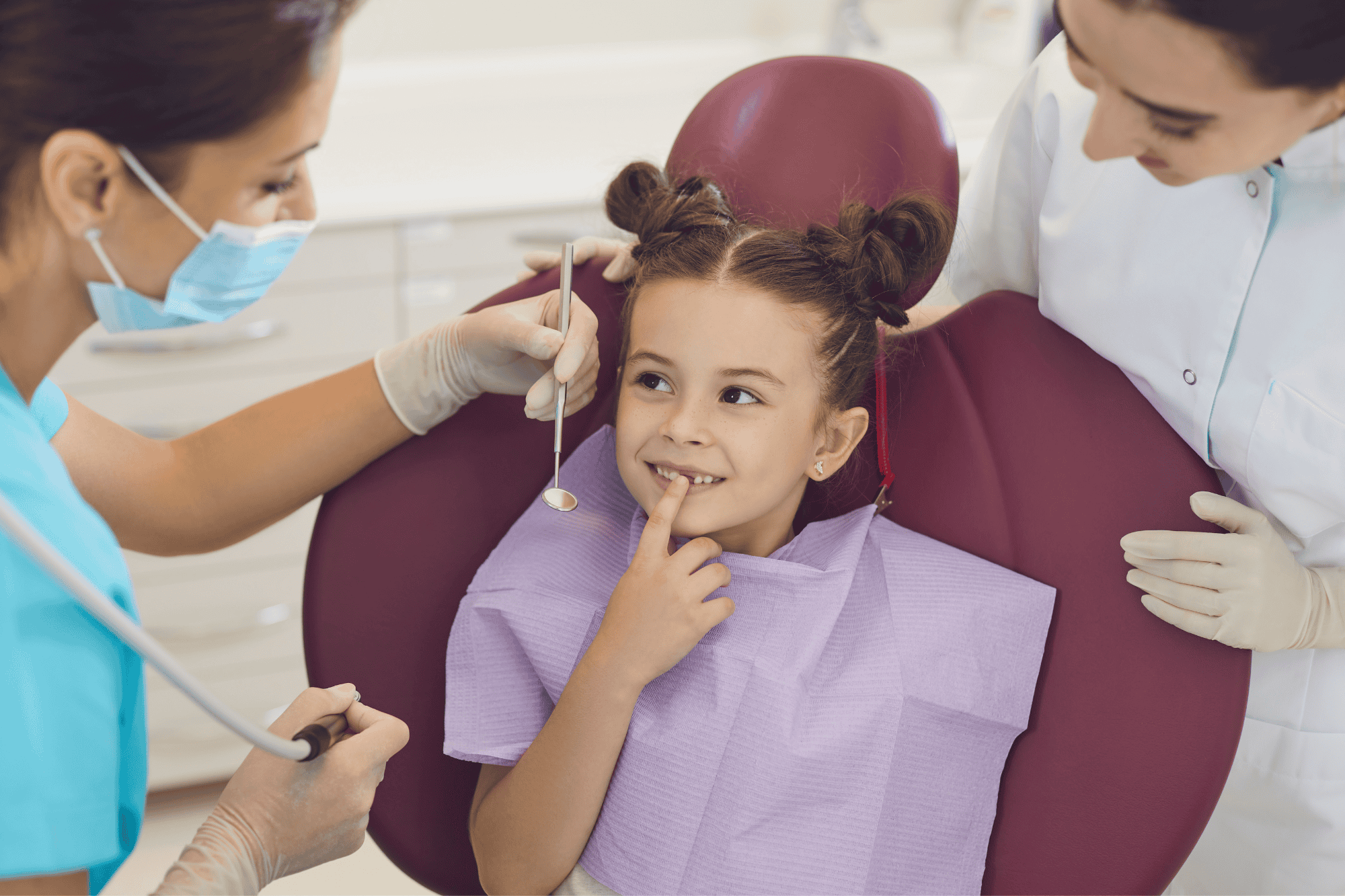 Primera Visita al Dentista en Niños: Cuándo Ir, Qué Esperar y Cómo Preparar a Tu Hijo 2 Odontopediatra enseñando un modelo dental a una niña pequeña durante su primera visita al dentista en Clínica Dental Benalúa Alicante