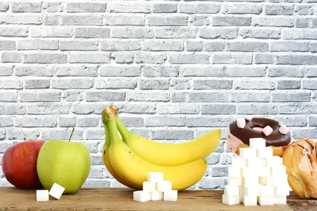 Terrones de azúcar junto a alimentos y bebidas que contienen azúcar