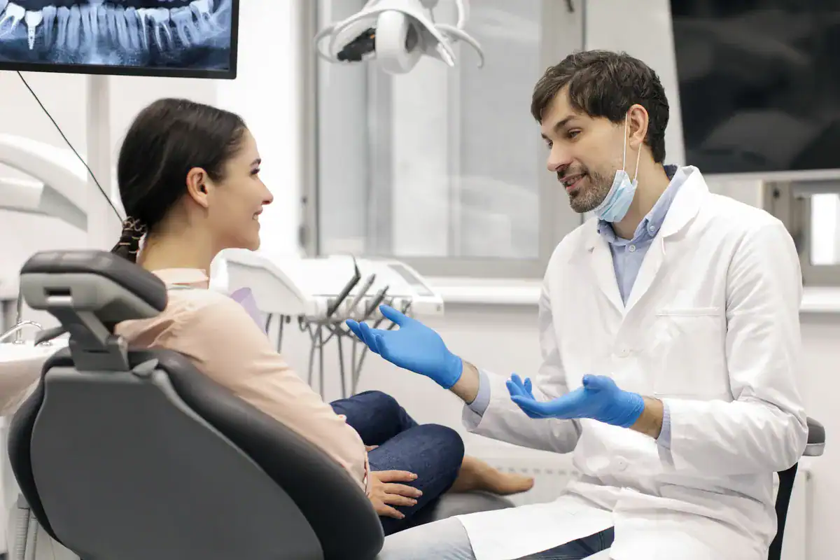 Dentista explicando el tratamiento a una paciente en la consulta
