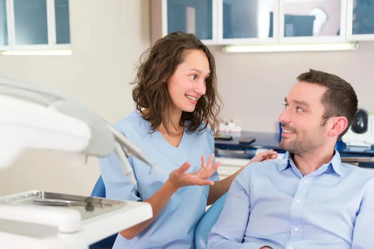 Dentista y paciente conversando con tranquilidad en la consulta