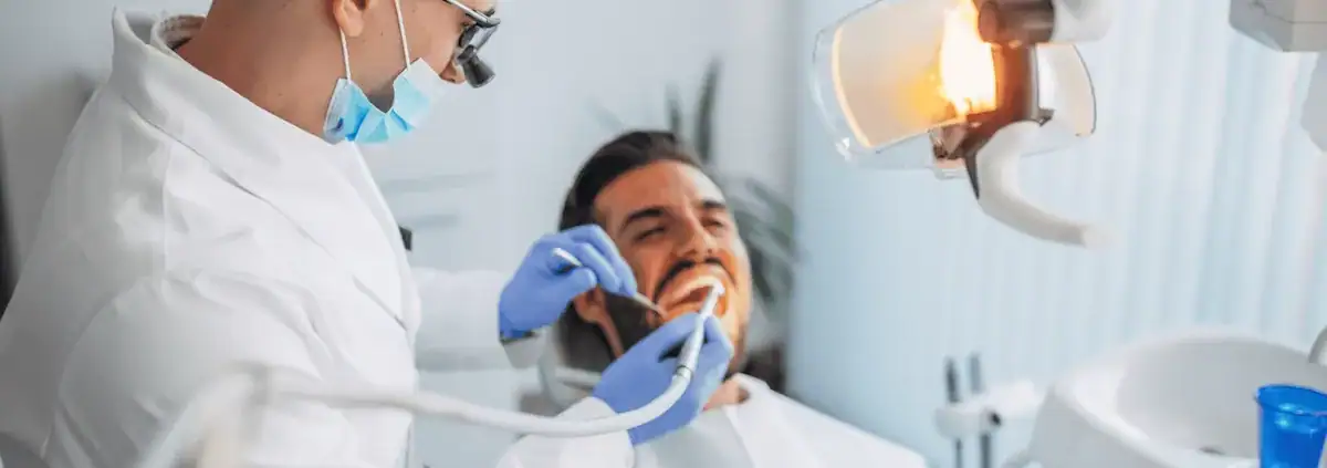 Dentista revisando a un paciente en el sillón dental
