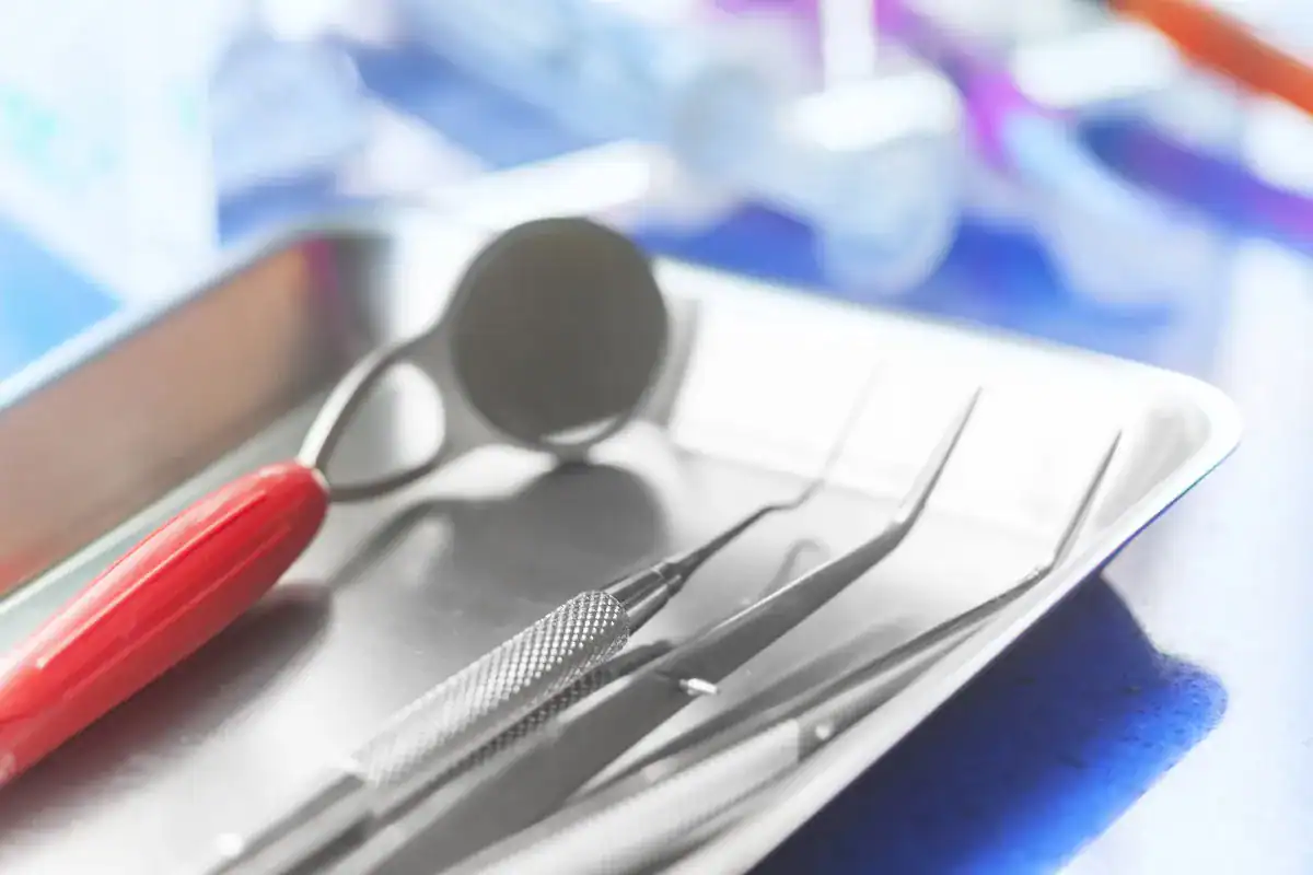 Espejo dental, sonda y pinzas sobre una bandeja de instrumental