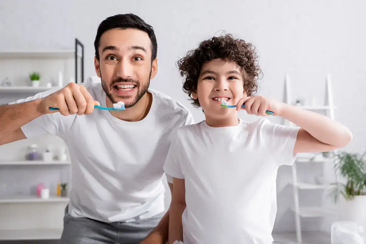 ¿Qué es la Odontopediatría? 13 Padre e hijo cepillándose los dientes juntos